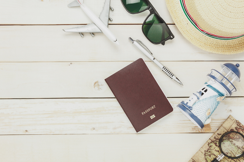 Top view accessories to travel beach with items notebook map passport airplane eyeglasses on white wooden background.copy space.top table.flat lay.above.vacation and holidays concept.